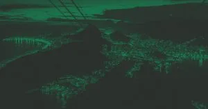 Foto com filtro verde da vista aérea da cidade do Rio de Janeiro à noite, com luzes acesas.