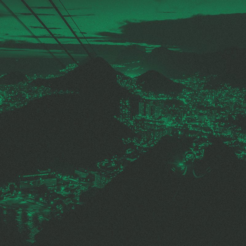 Foto com filtro verde da vista aérea da cidade do Rio de Janeiro à noite, com luzes acesas.